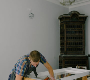 Timmerman werkt aan een houten raamkozijn in een werkplaats